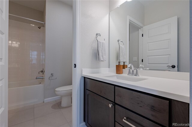 full bath featuring toilet, baseboards, tile patterned floors, vanity, and washtub / shower combination