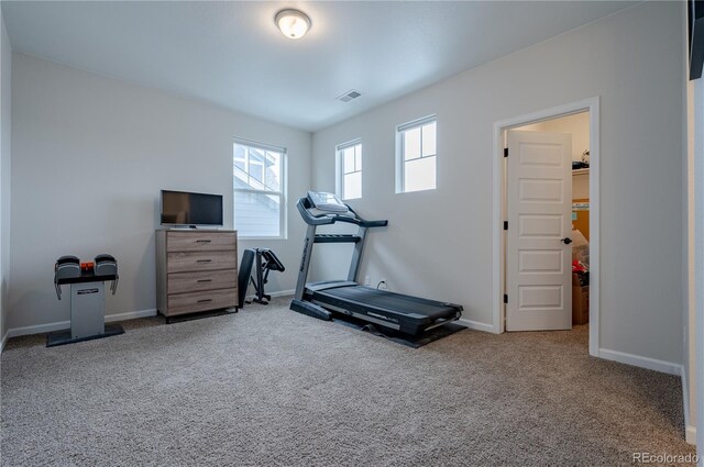 workout area featuring carpet and baseboards