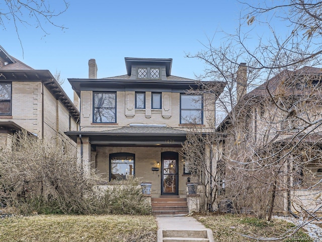 american foursquare style home with a porch and brick siding