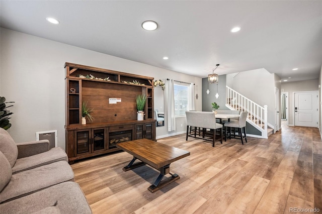 living room with light wood-type flooring and a chandelier