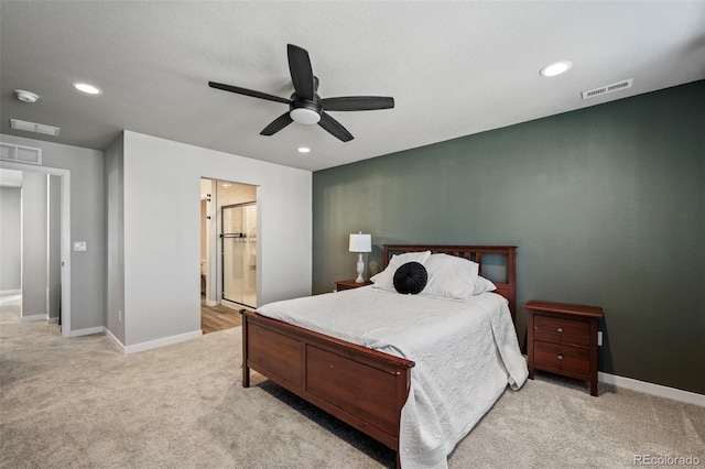 bedroom with connected bathroom, light carpet, and ceiling fan