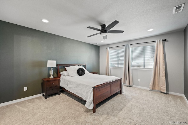 carpeted bedroom with ceiling fan and a textured ceiling