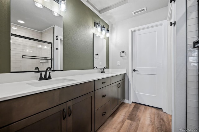 bathroom featuring an enclosed shower, vanity, and hardwood / wood-style floors