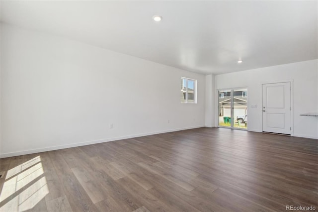 unfurnished living room with dark wood-style flooring, baseboards, and recessed lighting