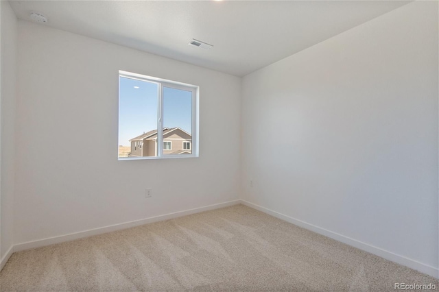 carpeted spare room with a smoke detector and baseboards