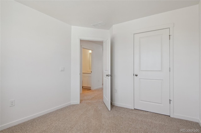 unfurnished bedroom with light colored carpet and baseboards