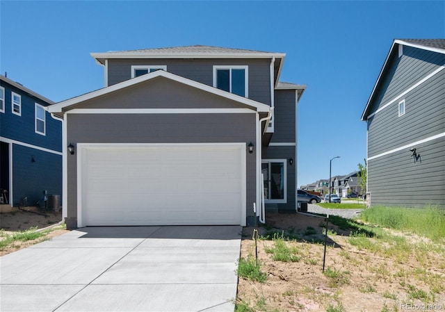 view of front of property with concrete driveway, a garage, and central AC