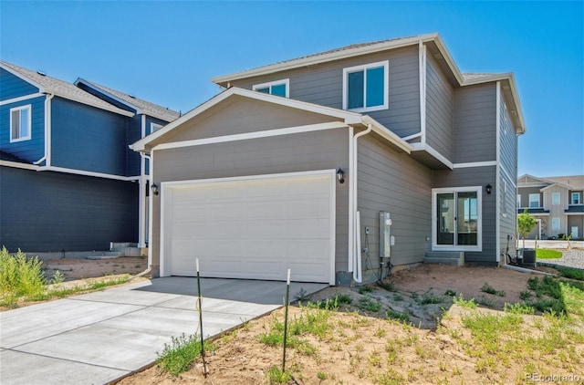 view of front of home with driveway, central AC, and an attached garage