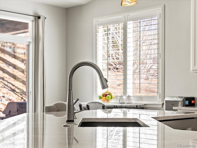 room details with a sink and light stone countertops