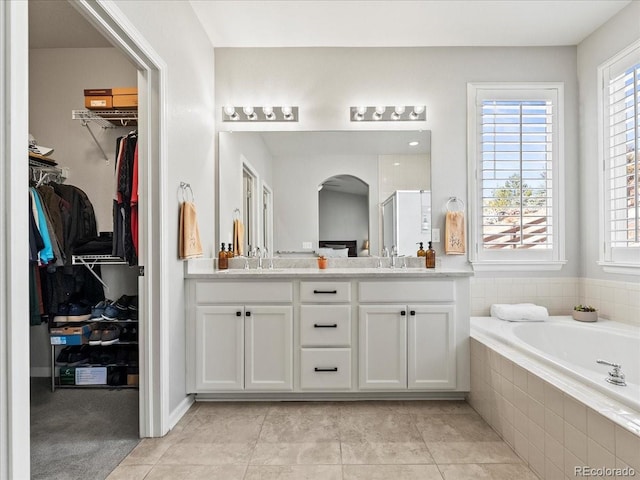 full bathroom with a stall shower, a walk in closet, a sink, and double vanity