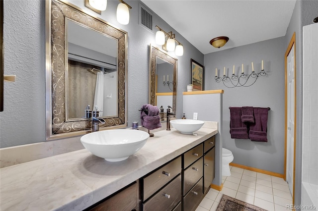 bathroom featuring tile patterned flooring, vanity, and toilet