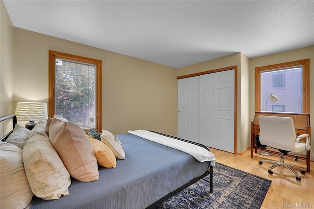 bedroom with hardwood / wood-style floors, a closet, and a textured ceiling