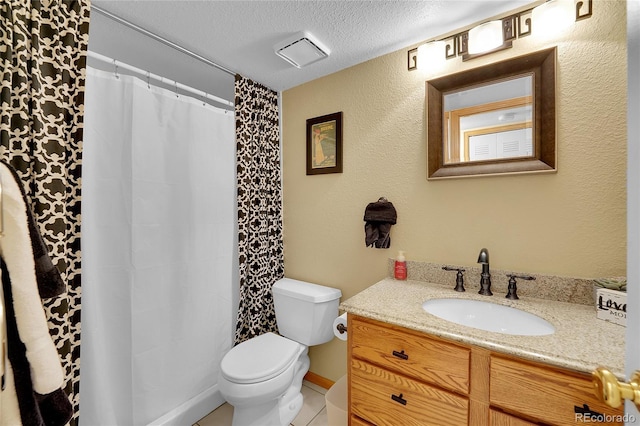 bathroom with vanity, toilet, and a textured ceiling