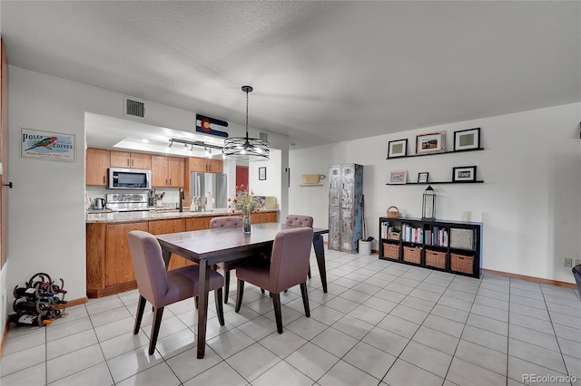 tiled dining space featuring a textured ceiling