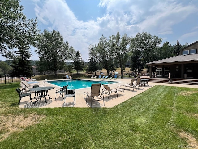 view of pool with a patio and a yard