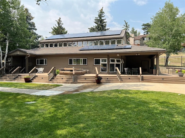 back of property with a patio area and solar panels