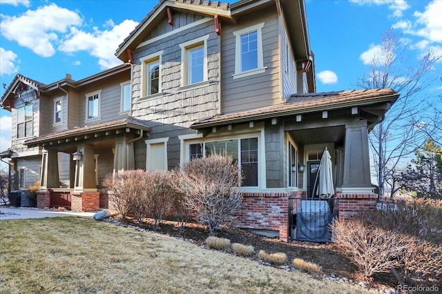 craftsman-style home with a front lawn, brick siding, and a chimney