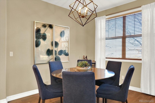 dining space with wood finished floors, baseboards, and a chandelier