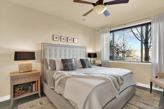 bedroom with ceiling fan, baseboards, and wood finished floors