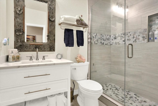 full bathroom featuring vanity, toilet, and a stall shower