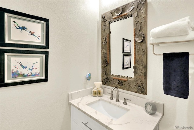 bathroom with vanity and a textured wall