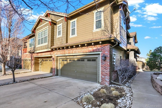 view of front of property featuring concrete driveway, a garage, and brick siding