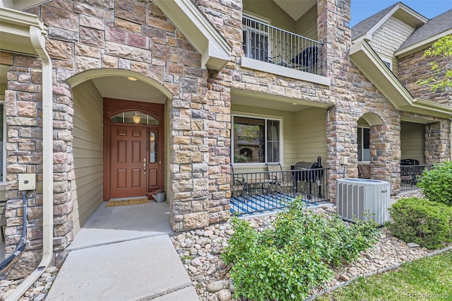 15362 W 66th Ave Unit D, Arvada, CO 80007 - doorway to property with central AC unit, a balcony, and stone siding