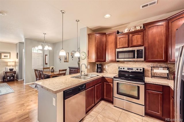 15362 W 66th Ave Unit D, Arvada, CO 80007 - kitchen with stainless steel appliances, a sink, backsplash, a peninsula, and pendant lighting