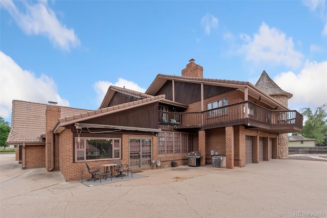 11485 Pecos St, Denver, CO 80234 - back of house with a chimney, brick siding, a garage, driveway, and a patio area
