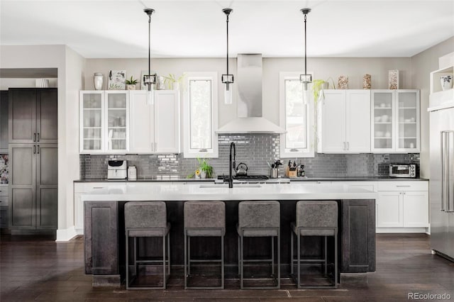 3255 S Birch St, Denver, CO 80222 - kitchen with wall chimney exhaust hood, backsplash, built in refrigerator, and dark wood-style floors