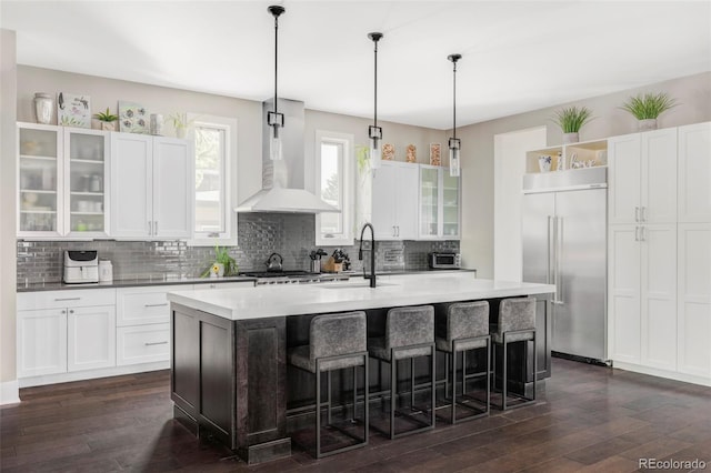 3255 S Birch St, Denver, CO 80222 - kitchen featuring built in fridge, wall chimney exhaust hood, open shelves, dark wood-style flooring, and backsplash