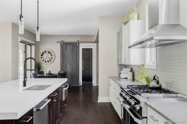 3255 S Birch St, Denver, CO 80222 - kitchen with wall chimney exhaust hood, appliances with stainless steel finishes, light countertops, white cabinets, and tasteful backsplash