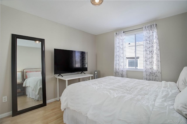 bedroom with light wood-type flooring and baseboards