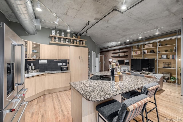 1499 Blake St Unit 4F, Denver, CO 80202 - kitchen featuring light brown cabinetry, high quality fridge, light wood finished floors, and track lighting