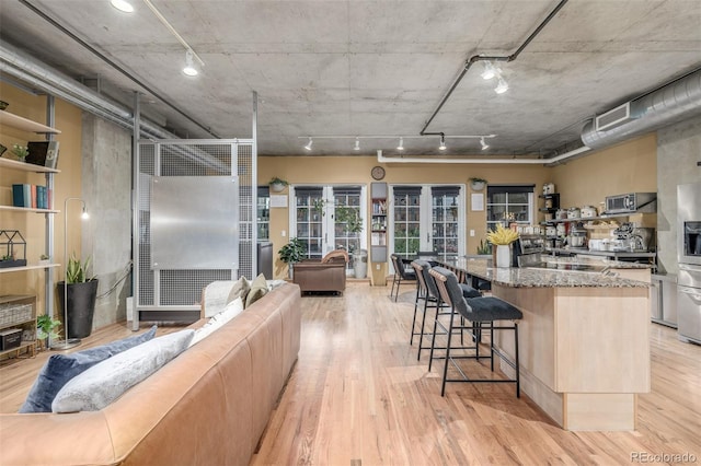 1499 Blake St Unit 4F, Denver, CO 80202 - kitchen with light stone counters, a center island, and light wood-style flooring