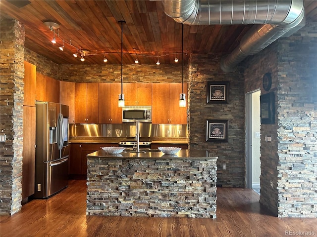 kitchen with stainless steel appliances, dark hardwood / wood-style floors, and a center island with sink