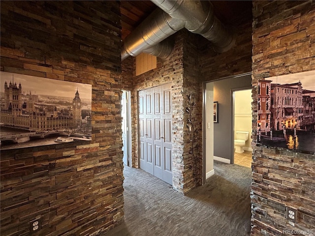 hallway featuring dark colored carpet