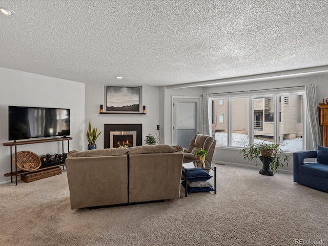 living area featuring a warm lit fireplace, carpet floors, a textured ceiling, and baseboards