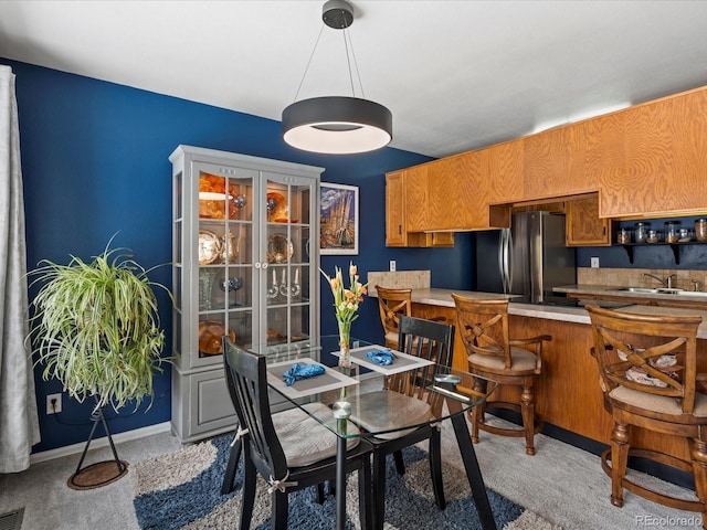 dining area with light colored carpet, visible vents, and baseboards