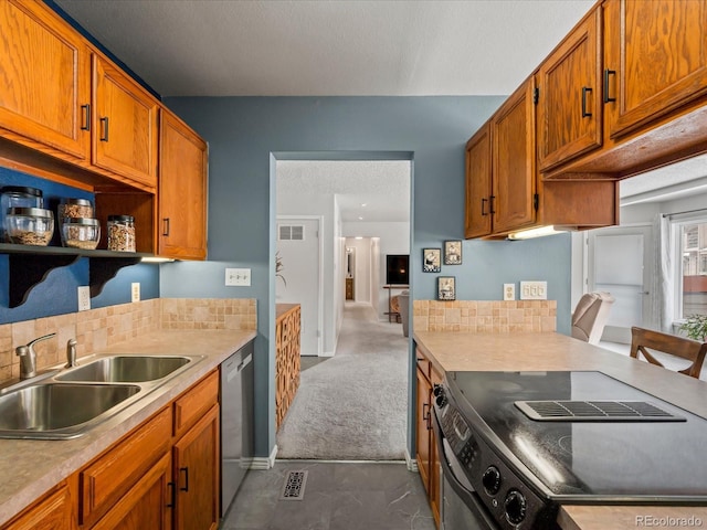 kitchen featuring brown cabinets, light countertops, electric range oven, stainless steel dishwasher, and a sink