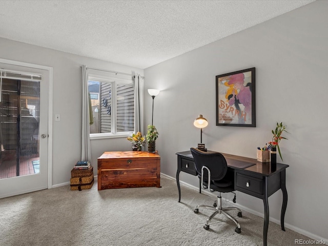 office with carpet, baseboards, and a textured ceiling