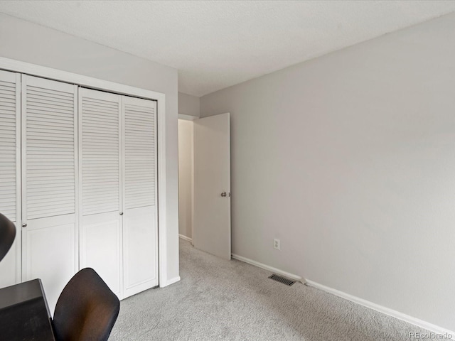 unfurnished office featuring light colored carpet, visible vents, and baseboards