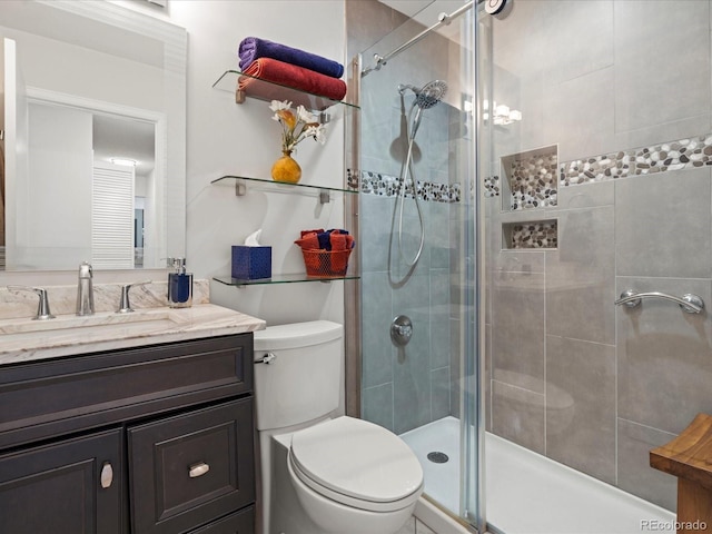 full bath with a stall shower, vanity, and toilet