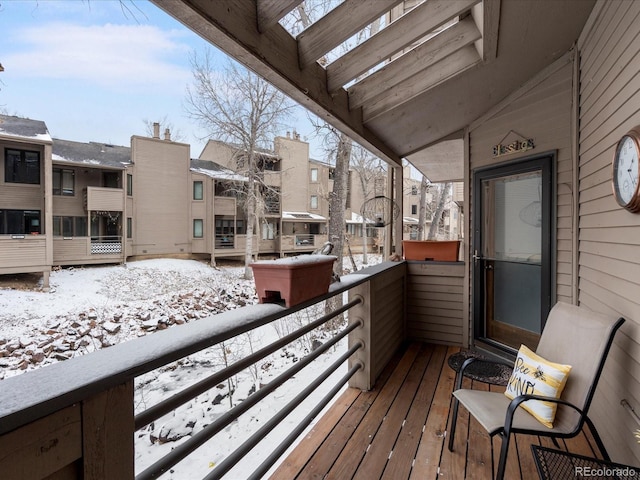 snow covered back of property featuring a residential view