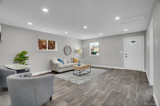 living area featuring baseboards, wood finished floors, and recessed lighting