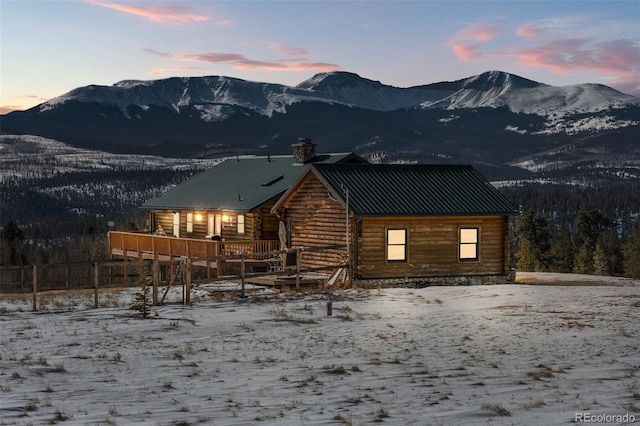 snow covered property featuring a deck with mountain view