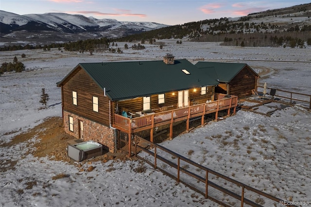 snow covered property featuring a deck with mountain view