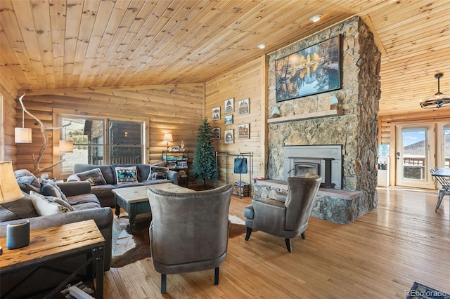 living room with a stone fireplace, log walls, wooden ceiling, hardwood / wood-style floors, and lofted ceiling