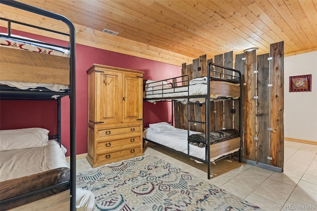 bedroom with wood ceiling and light tile patterned floors