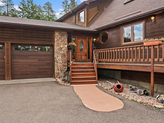13094 Molly Dr, Conifer, CO 80433 - entrance to property with a garage, roof with shingles, driveway, and stone siding